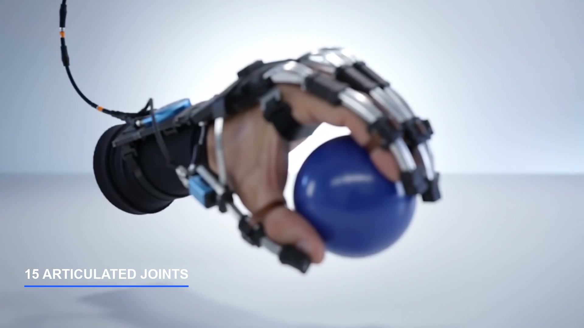 A frame from Exo Hand, Hypermotion: an extreme macro of a cable-driven hand exoskeleton&rsquo;s wrist actuator on a cool-lit studio void.